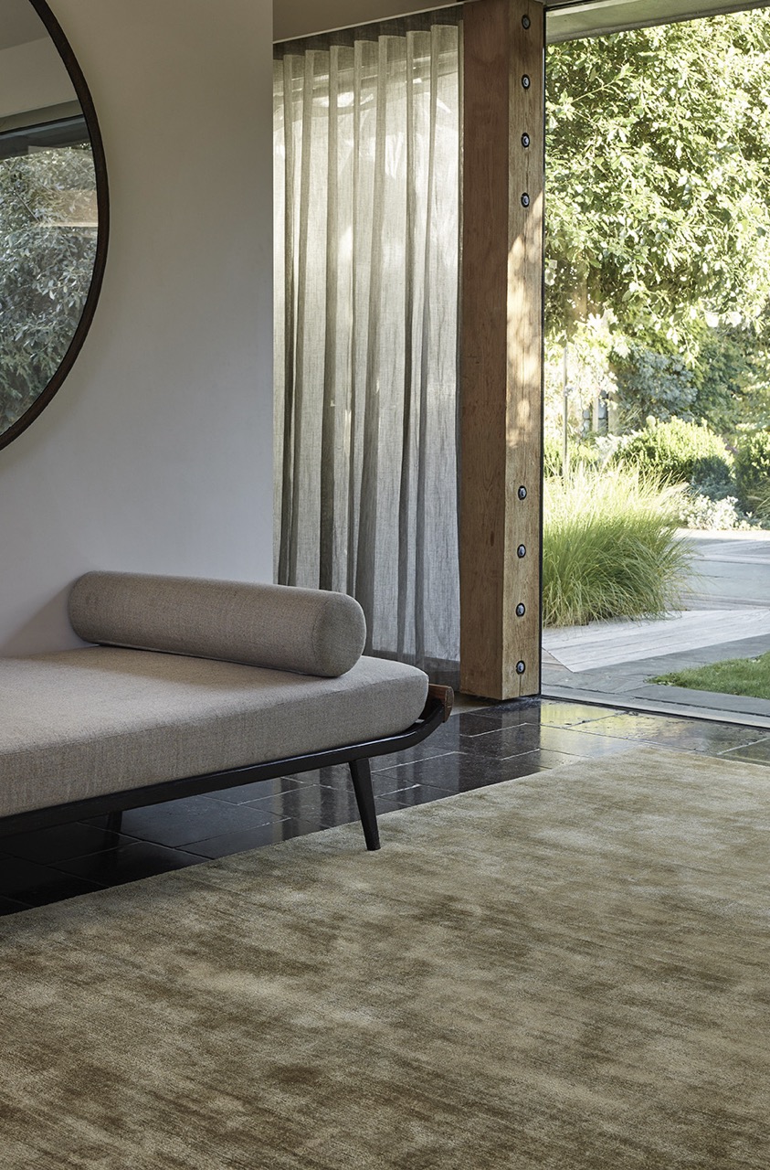light-colored rug on black tile floor