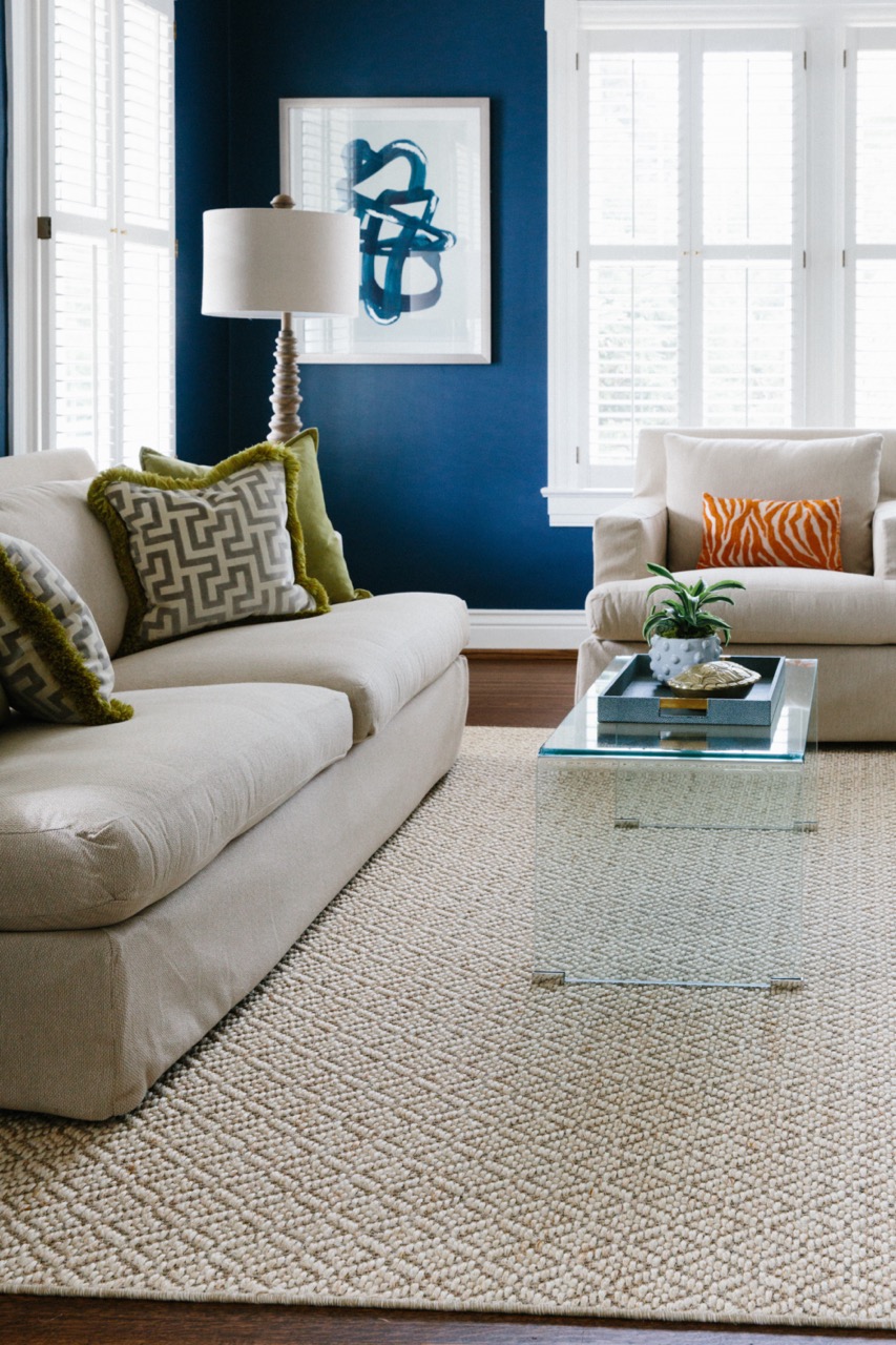 living room with sisal rug in beige color with colorful accessories