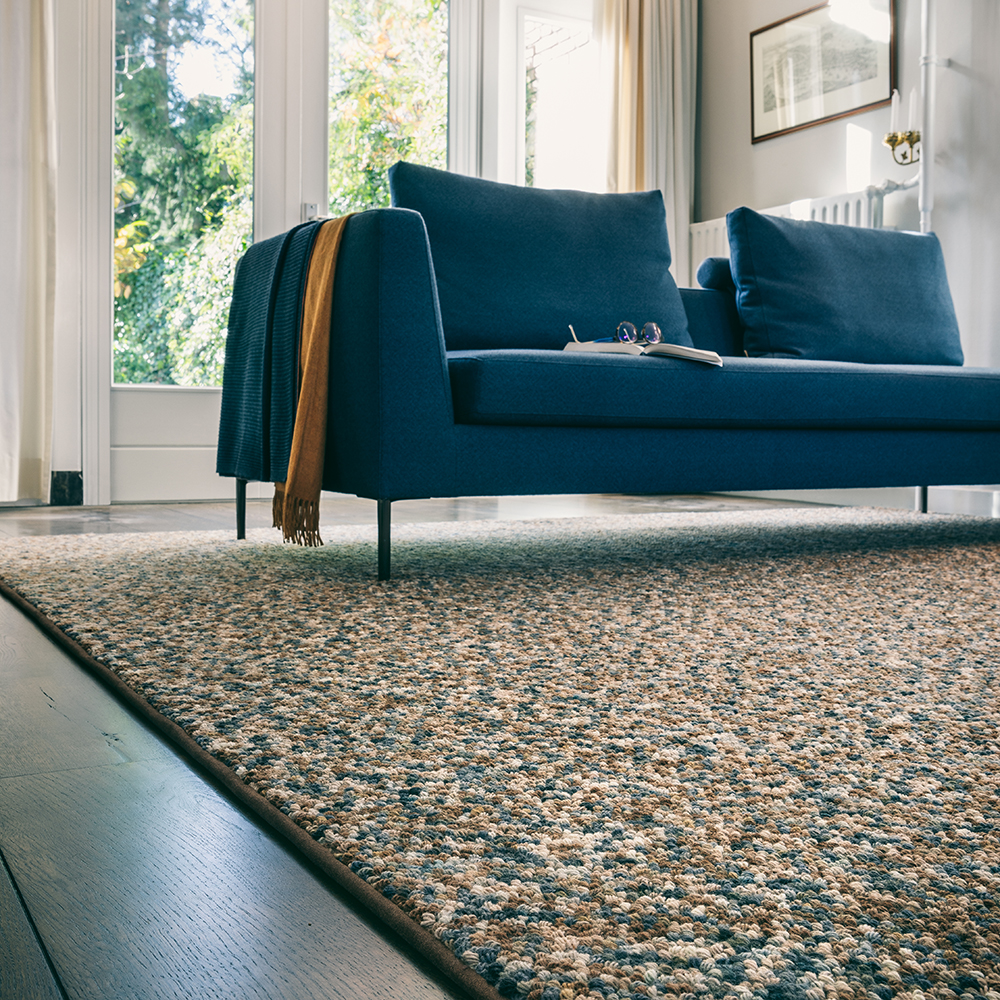 a multi-colored rug matches the blue sofa